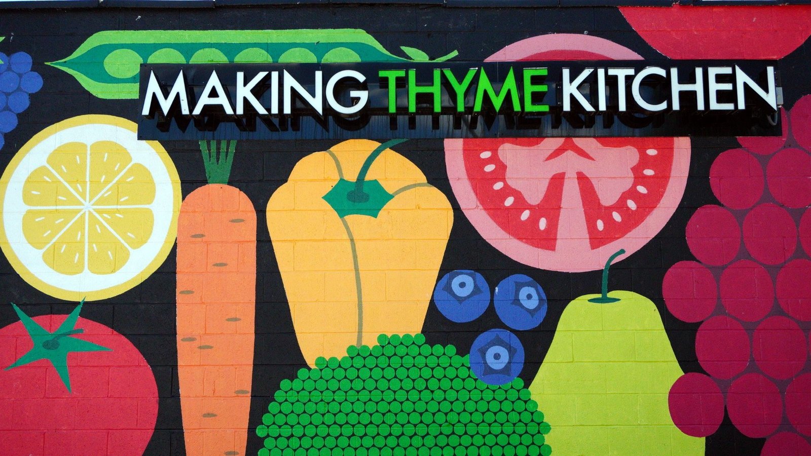The Making Thyme Kitchen fruit and vegetable mural and sign on the building